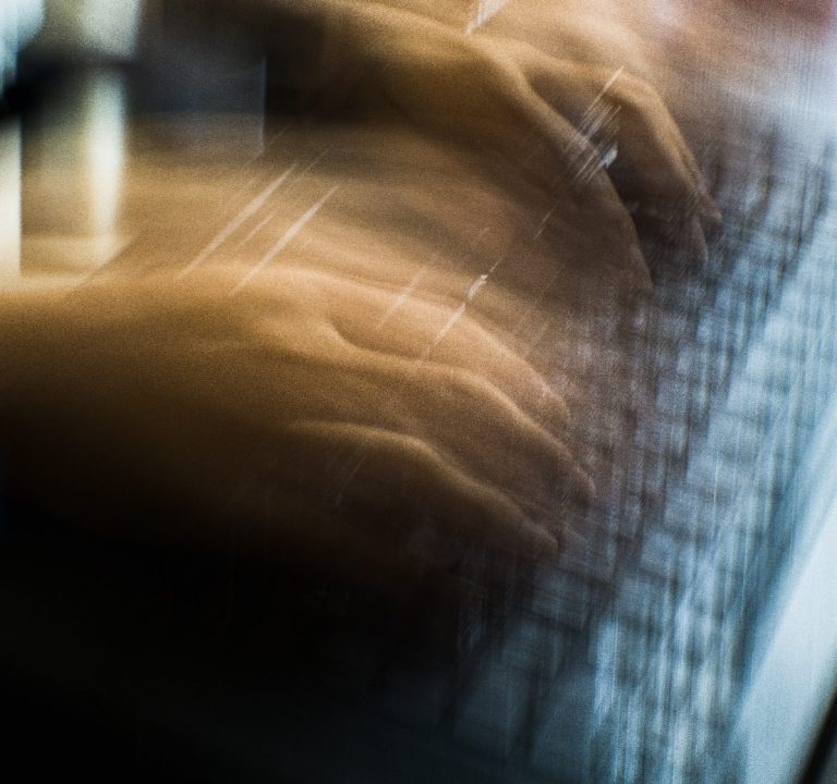 Hände auf einer Tastatur, die gerade an einem Drehbuch tippen.